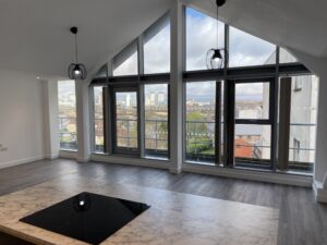 An image of a kitchen and open plan living room in an apartment at St Line House, Cardiff