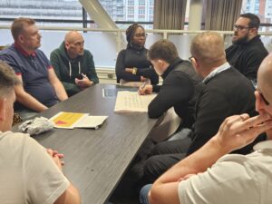 An image of United Welsh employees talking to each other at a table at a staff event